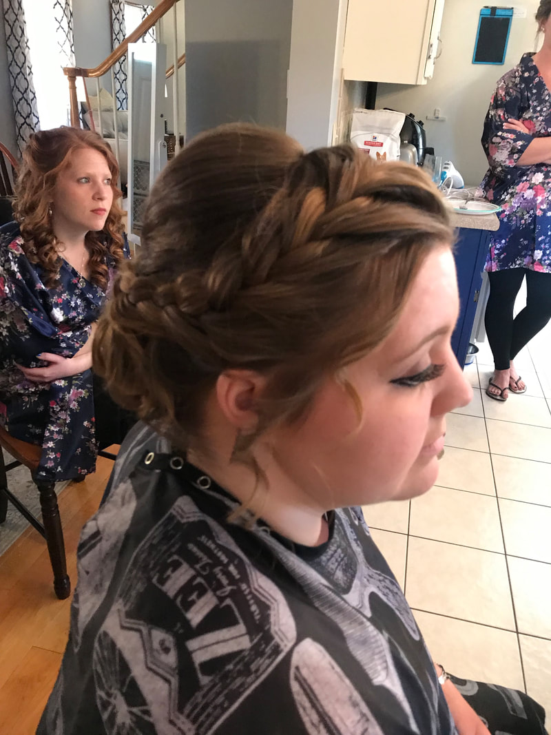 Picture of bride who has a semi crown braid her hair slightly bumped up in the back and then pinned at the bottom