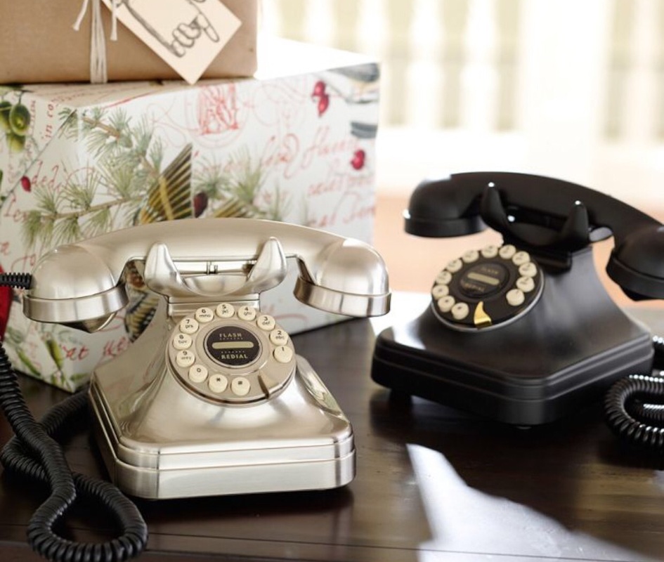 Two telephones, one silver and one black with two wrapped boxes in the background